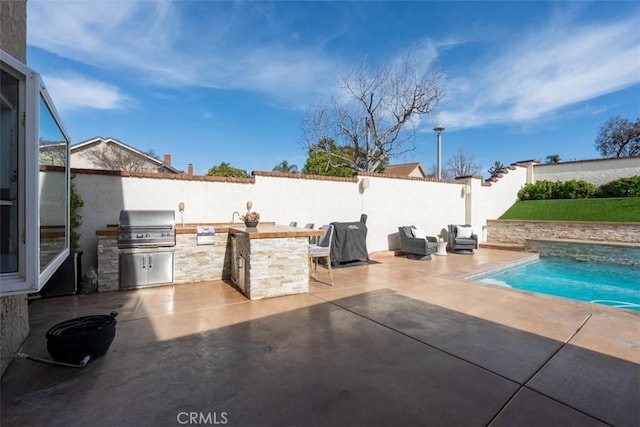 view of patio / terrace with an outdoor kitchen, a grill, a fenced backyard, and a fenced in pool