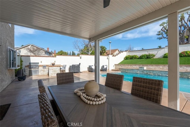 view of patio / terrace with outdoor dining area, a fenced in pool, exterior kitchen, and a fenced backyard