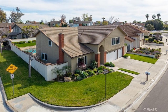 view of front of home featuring a tiled roof, fence, a residential view, and stucco siding