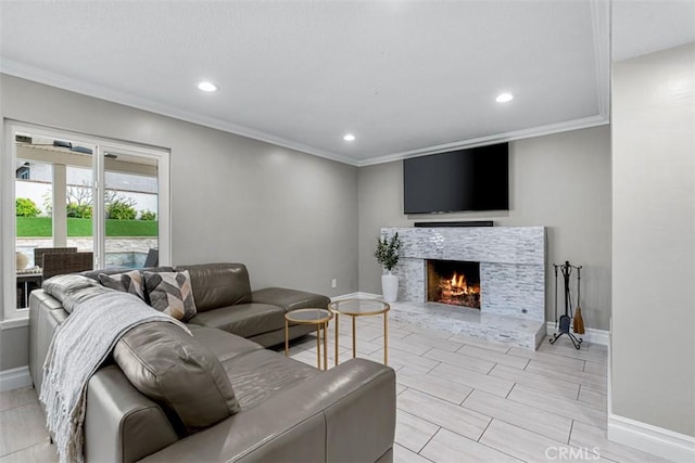 living room with recessed lighting, baseboards, a warm lit fireplace, and crown molding