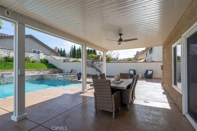 view of patio featuring a pool with connected hot tub, outdoor dining space, a ceiling fan, and fence