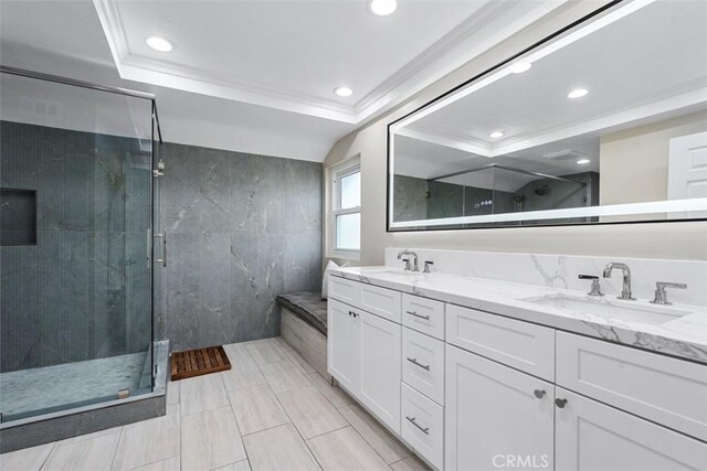 full bathroom featuring a shower stall, ornamental molding, double vanity, and a sink