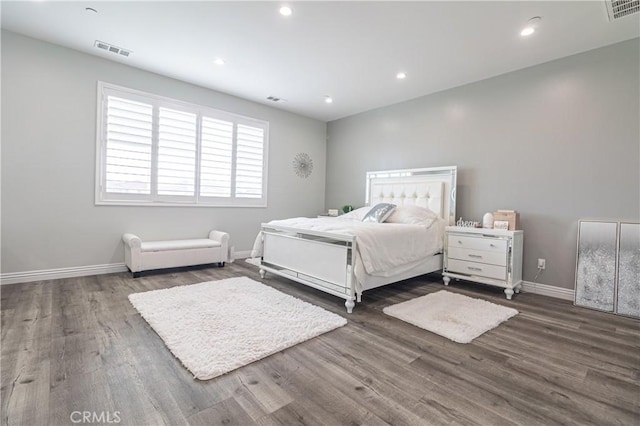 unfurnished bedroom with visible vents, baseboards, and wood finished floors