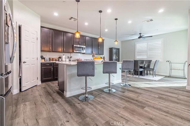 kitchen with a breakfast bar area, visible vents, appliances with stainless steel finishes, and ceiling fan