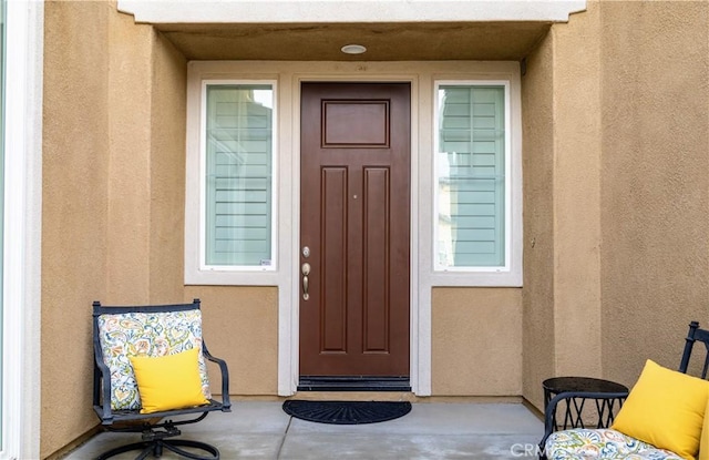 entrance to property featuring stucco siding