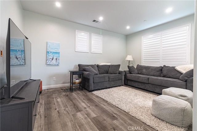 living room with visible vents, recessed lighting, baseboards, and wood finished floors