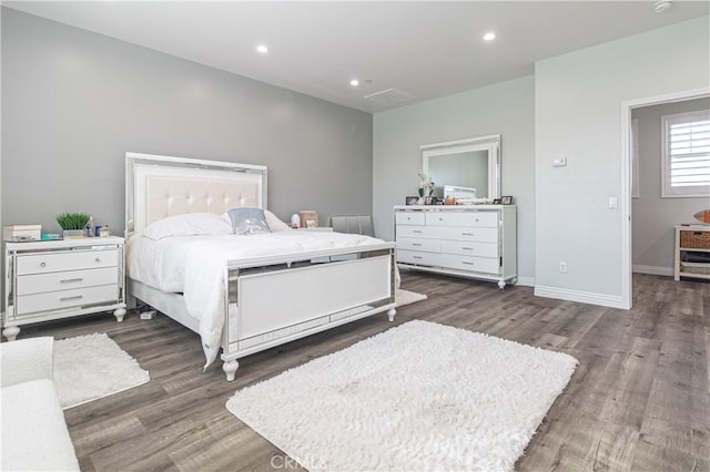 bedroom with recessed lighting, wood finished floors, and baseboards