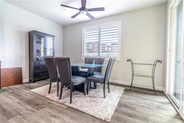 dining area with wood finished floors, baseboards, and ceiling fan