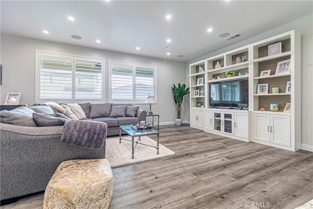 living area featuring recessed lighting, visible vents, baseboards, and wood finished floors