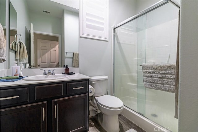 full bathroom featuring visible vents, a shower stall, toilet, and vanity