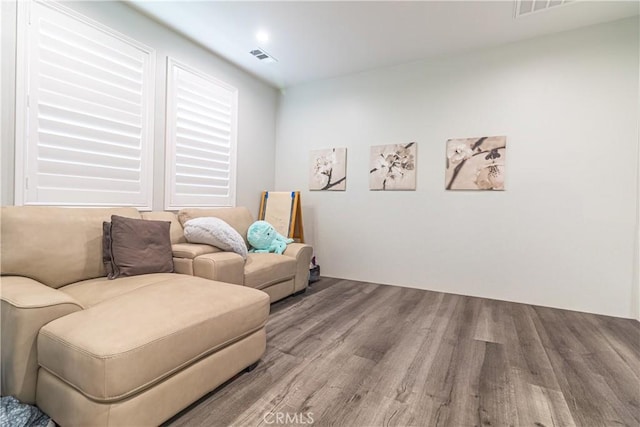 living area featuring visible vents and wood finished floors