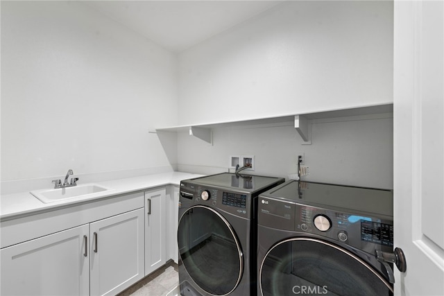 laundry area with cabinet space, independent washer and dryer, and a sink