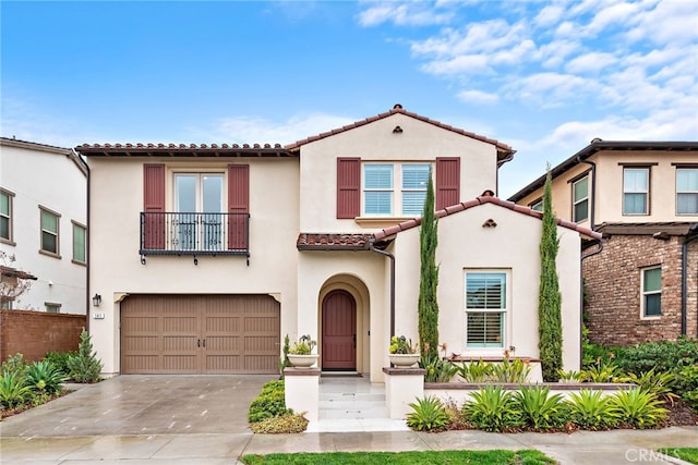 mediterranean / spanish home featuring stucco siding, a garage, a balcony, and driveway