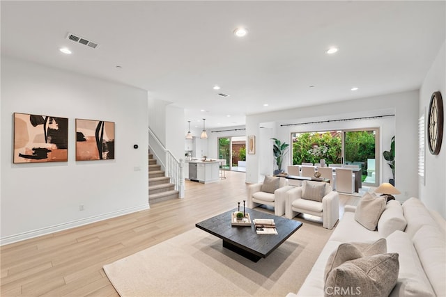 living area featuring visible vents, recessed lighting, stairs, and light wood-type flooring