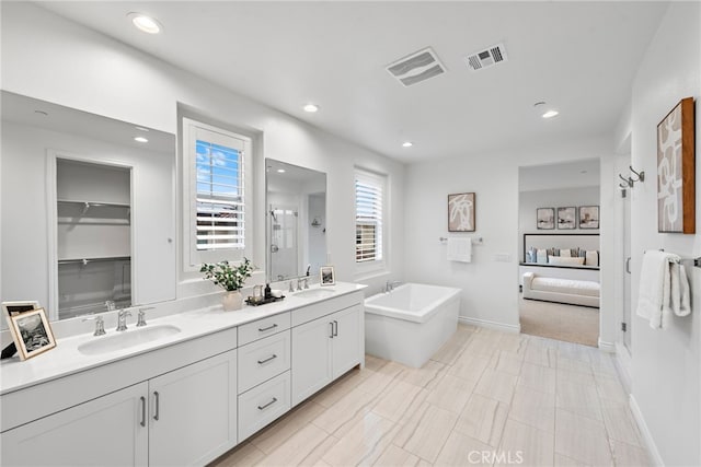 ensuite bathroom with visible vents, a shower stall, and a sink