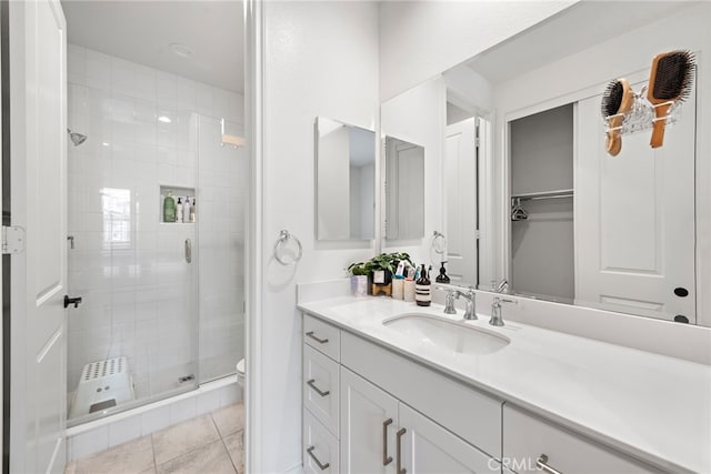 bathroom featuring vanity, a shower stall, toilet, and tile patterned flooring