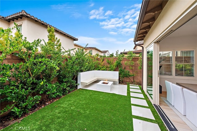 view of yard with a fenced backyard, a fire pit, and a patio