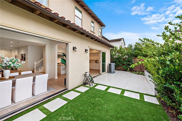 view of yard with a patio area, fence, and central AC