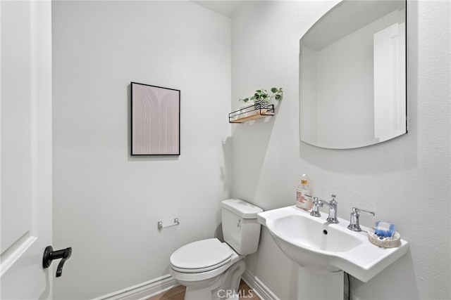 half bath with baseboards and toilet