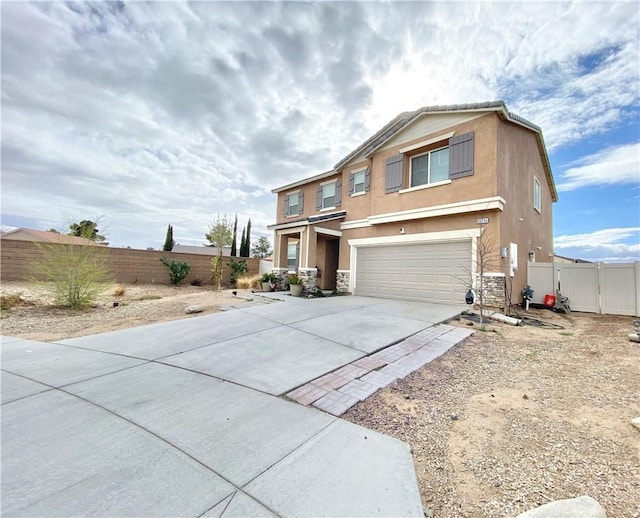 view of front of house with an attached garage, fence, driveway, and stucco siding