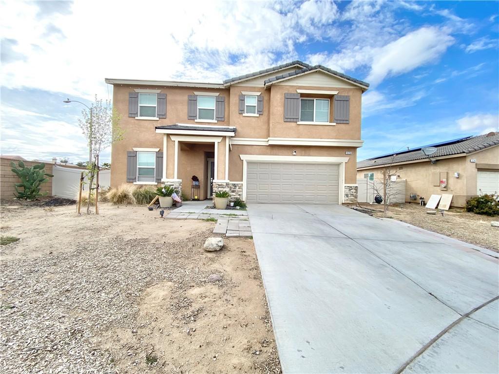 view of front facade featuring fence, an attached garage, stucco siding, concrete driveway, and stone siding