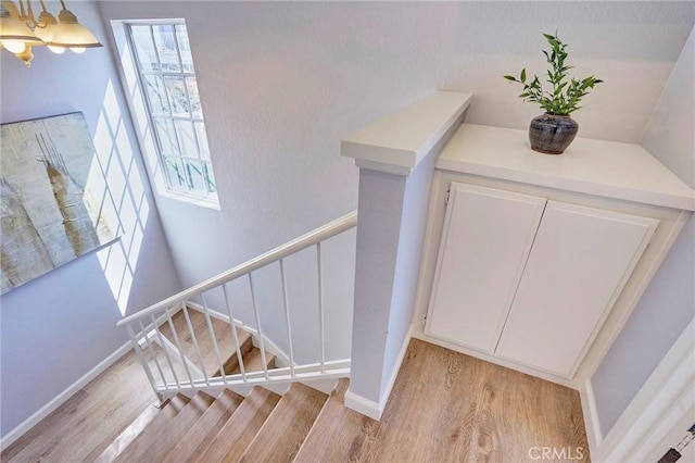 stairs with wood finished floors and baseboards