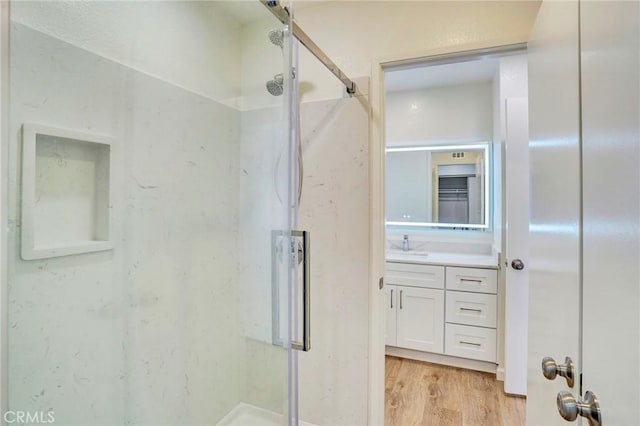 bathroom with a shower stall, vanity, and wood finished floors