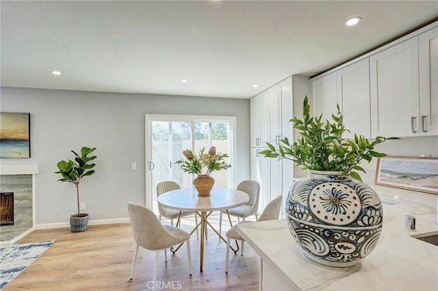 dining space featuring recessed lighting, baseboards, and light wood-type flooring