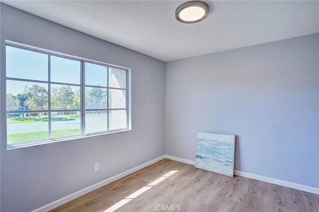 spare room with wood finished floors and baseboards