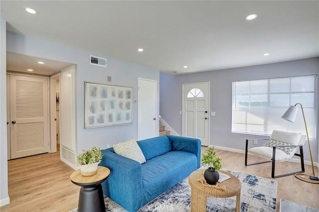 living room featuring stairs, recessed lighting, visible vents, and light wood-type flooring