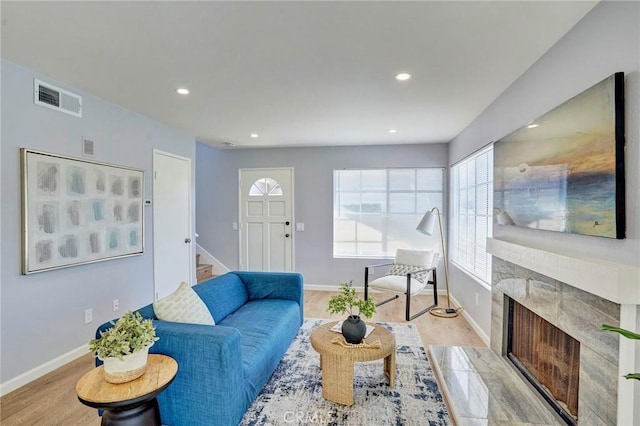 living area with recessed lighting, visible vents, light wood-style floors, and a fireplace