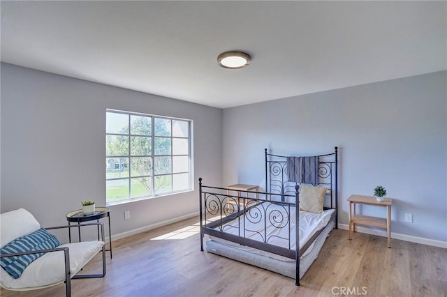 bedroom with light wood-type flooring and baseboards