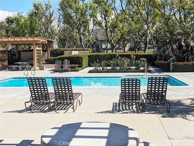 community pool with a pergola and a patio area