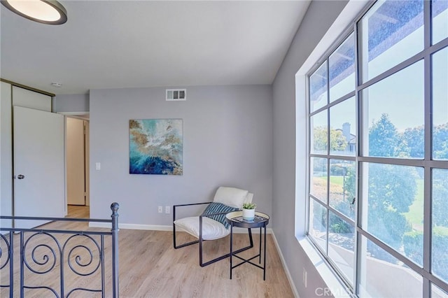 sitting room featuring visible vents, baseboards, and light wood-style flooring