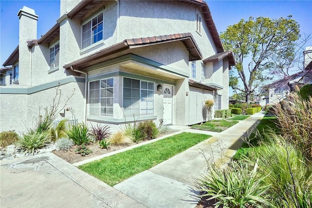 view of front of property featuring stucco siding and a chimney