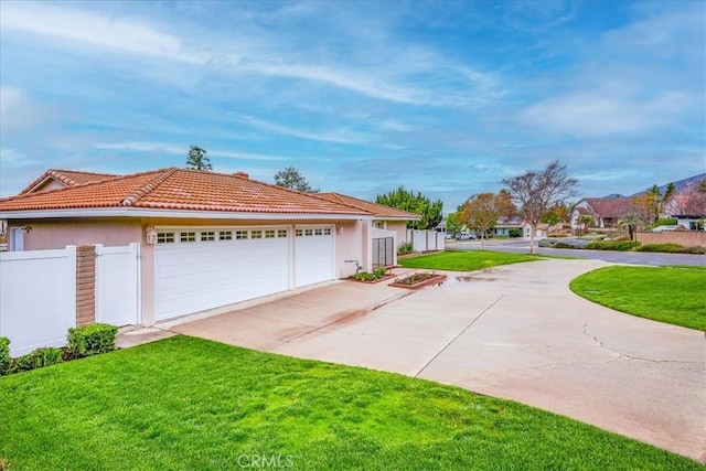 exterior space featuring stucco siding, fence, a yard, concrete driveway, and an attached garage