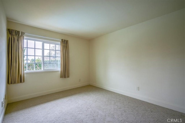 carpeted empty room with baseboards