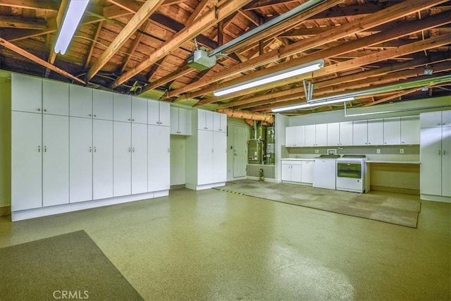 garage with a garage door opener and independent washer and dryer