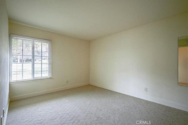 carpeted spare room with baseboards