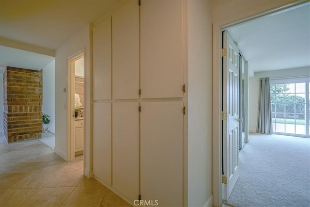 hall featuring light carpet and light tile patterned flooring