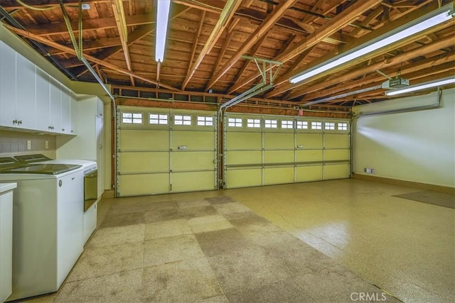 garage featuring washer and clothes dryer, a garage door opener, and baseboards