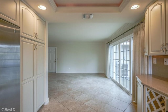 interior space featuring stainless steel built in fridge, visible vents, recessed lighting, crown molding, and a raised ceiling