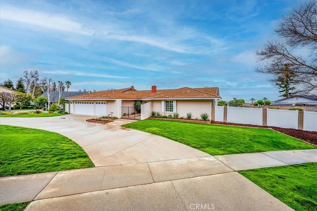 view of front of house with a garage, driveway, a front lawn, and fence