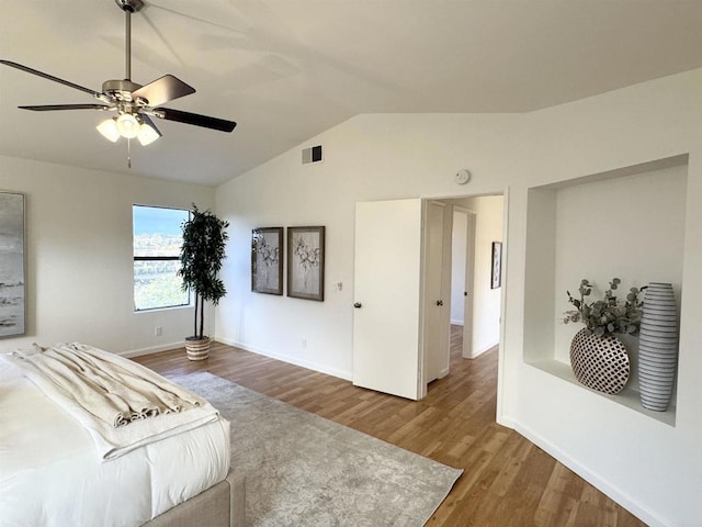 bedroom featuring wood finished floors, baseboards, visible vents, lofted ceiling, and ceiling fan