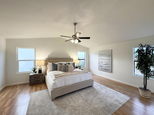 bedroom with vaulted ceiling, a ceiling fan, baseboards, and wood finished floors