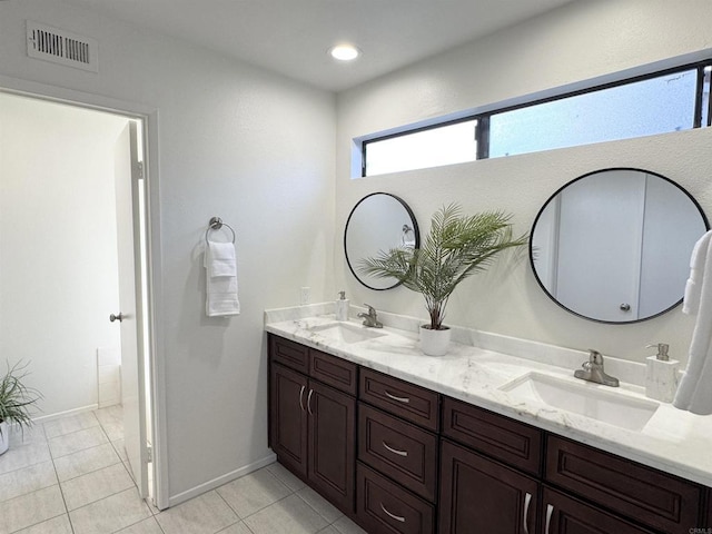 full bathroom featuring tile patterned flooring, double vanity, visible vents, and a sink