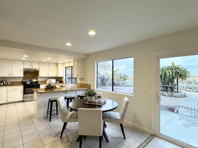 dining space featuring light tile patterned floors, recessed lighting, and baseboards