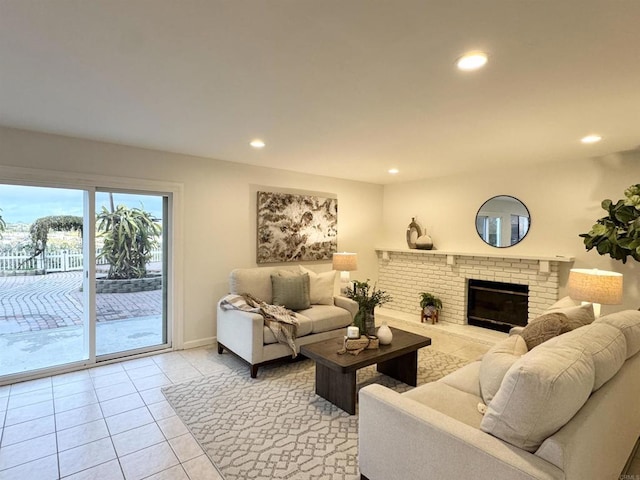 living area featuring a brick fireplace, light tile patterned floors, recessed lighting, and baseboards