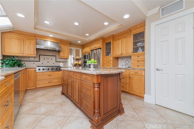 kitchen featuring visible vents, stainless steel appliances, wall chimney exhaust hood, light tile patterned floors, and a raised ceiling