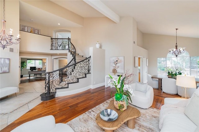 living room with stairway, a notable chandelier, and high vaulted ceiling